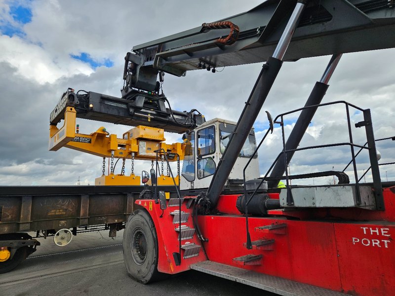 Battery-powered electro-permanent lifting magnet mounted on a forklift handling a steel slab